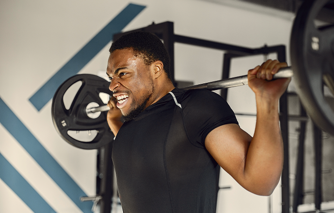 Athletic man lifting weights during gym workout fueled by Johnvents Pure Cocoa